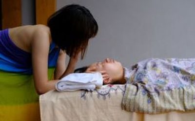 整合按摩过程中，治疗师双手温柔地托住客户的头部